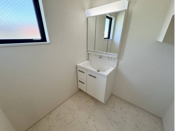 窓からの光で明るく清潔感のある、三面鏡付きの洗面化粧台です