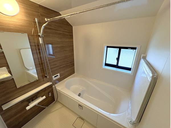 リラックスできる木目調のバスルーム。窓付きで換気もスムーズな清潔空間